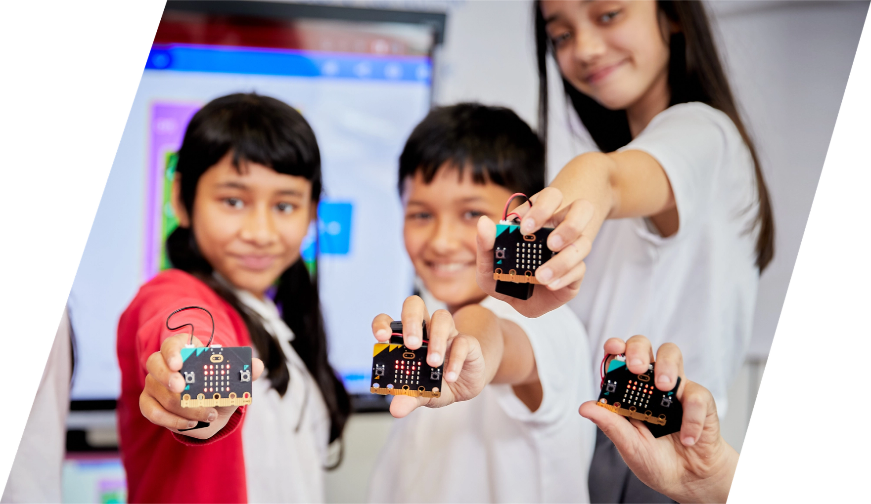 children in class smiling and holding micro:bits